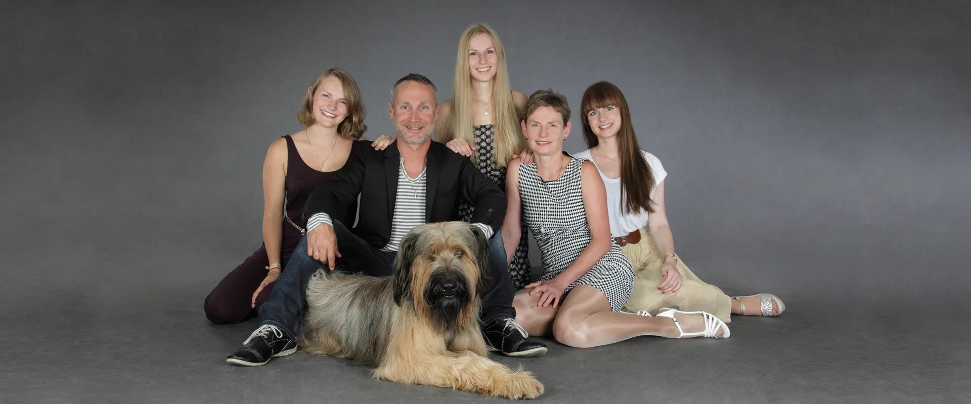 Portrait einer Familie mit ihrem Hund aufgenommen in unserem Fotostudio