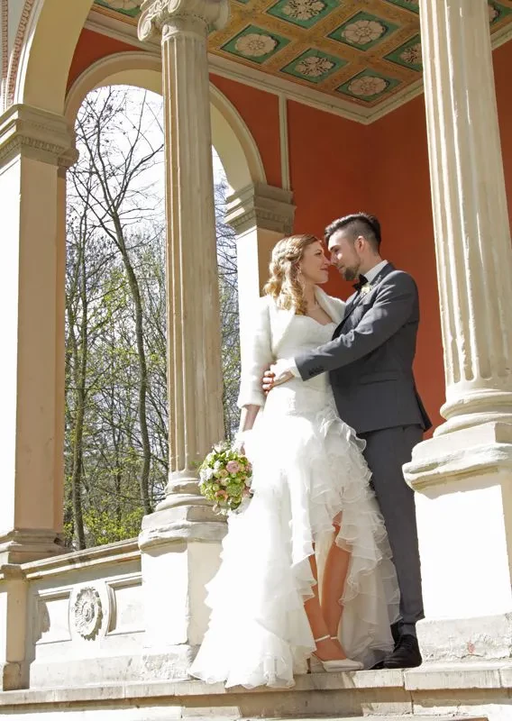 Junges Brautpaar an einer Kapelle im Park